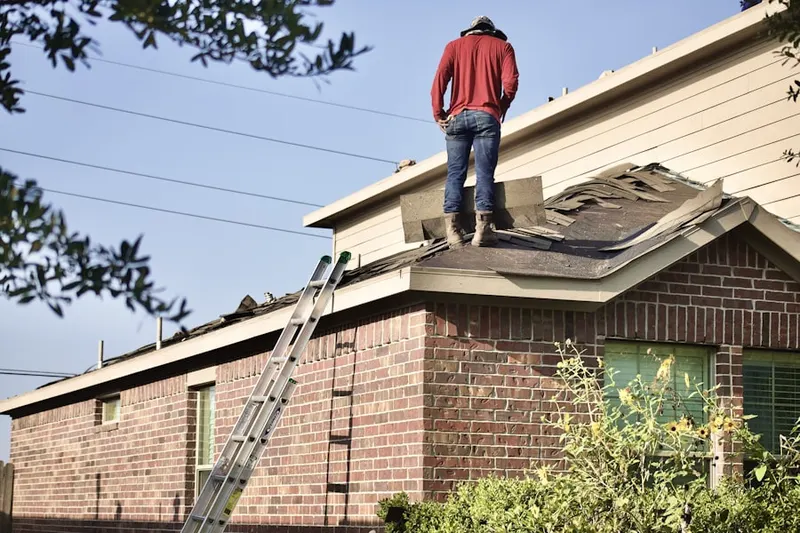 Professional roofer working on a residential roof in Hedding